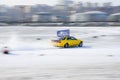 Yellow car races along the course during the ice drifting competition